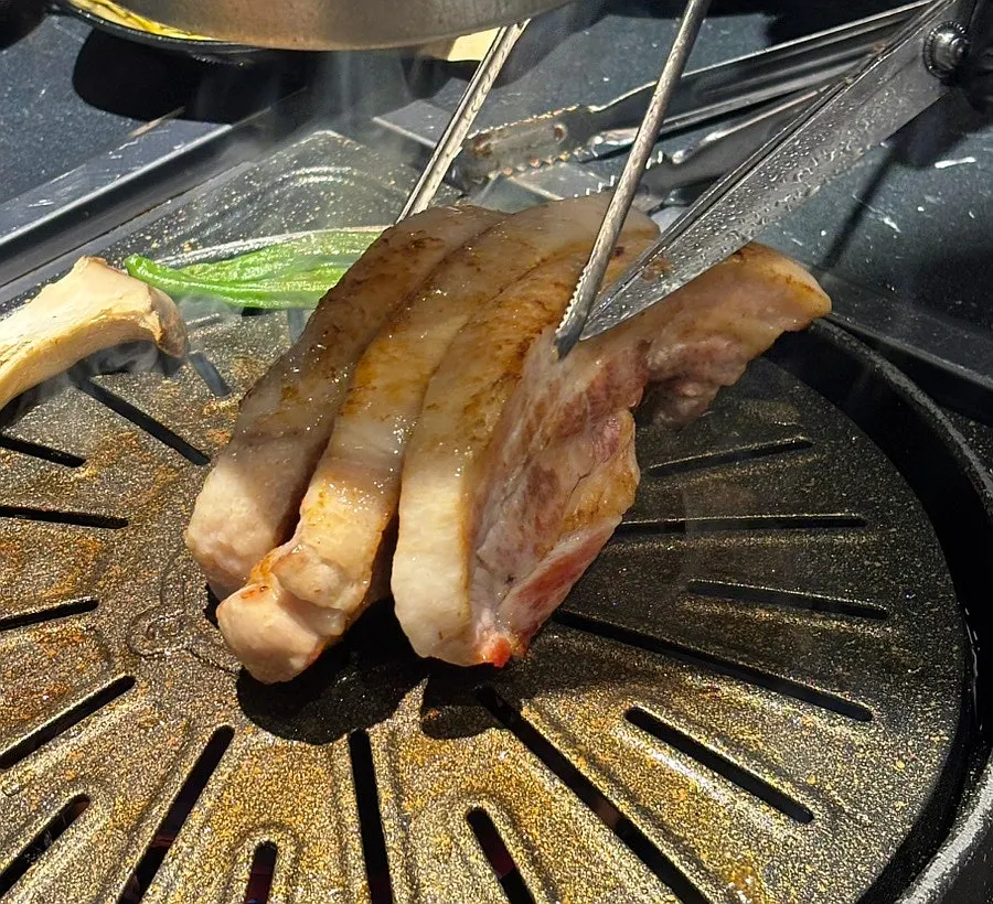 Staff member grilling pork belly