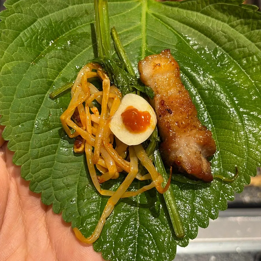 Sesame leaf wrap topped with minari and bean sprouts