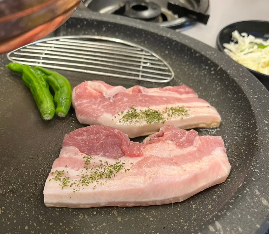 Pork belly cooking on the grill plate