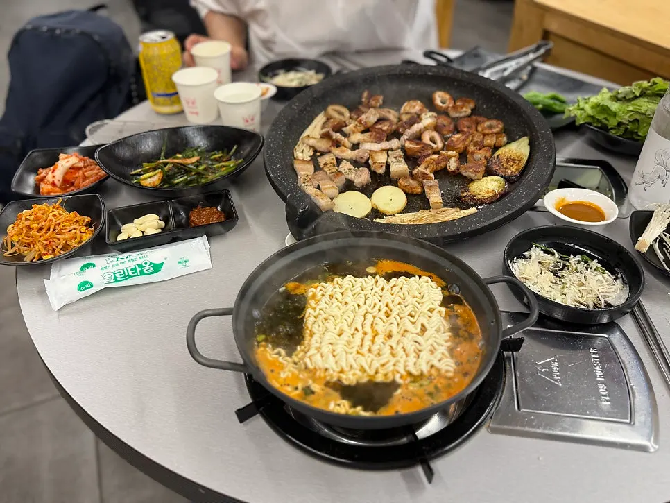 테이블 화구에서 끓이는 오동통면과 옆 불판의 고기