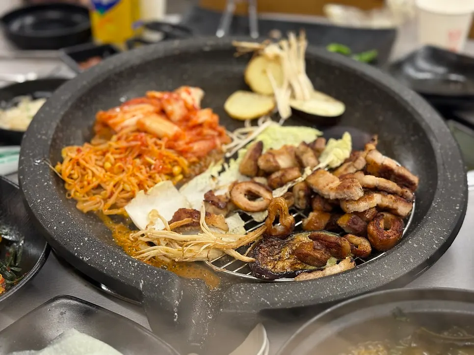 불판 위 구운 김치와 콩나물, 가지, 팽이버섯