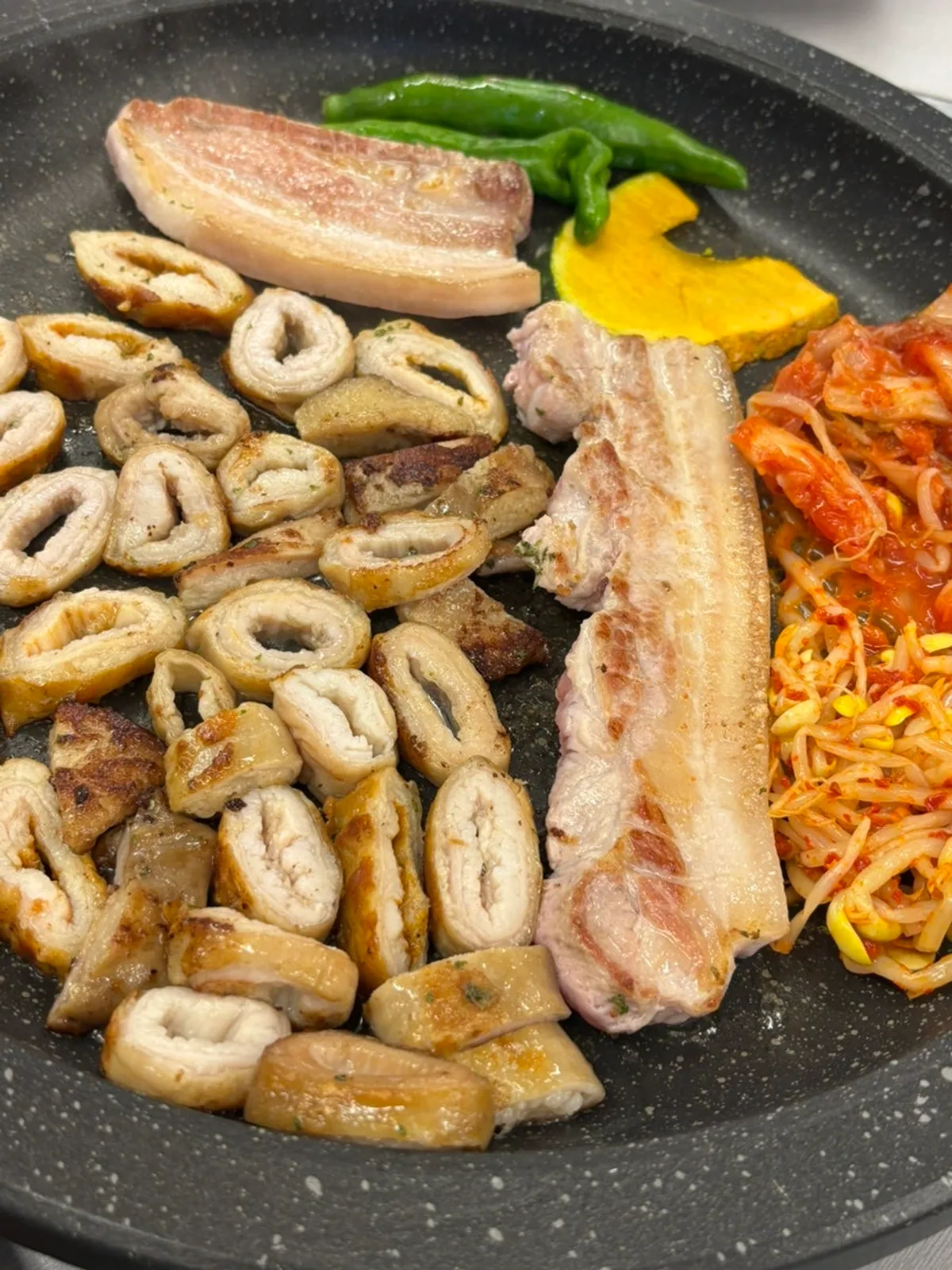 불판에서 구워지는 초벌 막창과 삼겹살