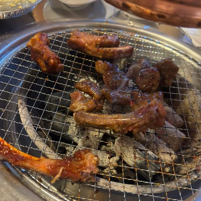A piece of jjokgalbi dipped in ranch sauce