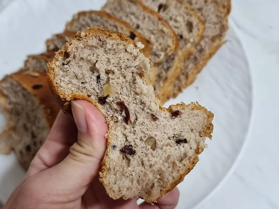 A slice of chalbori loaf held by hand