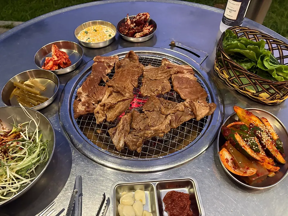 Outdoor table after dark with meat grilling