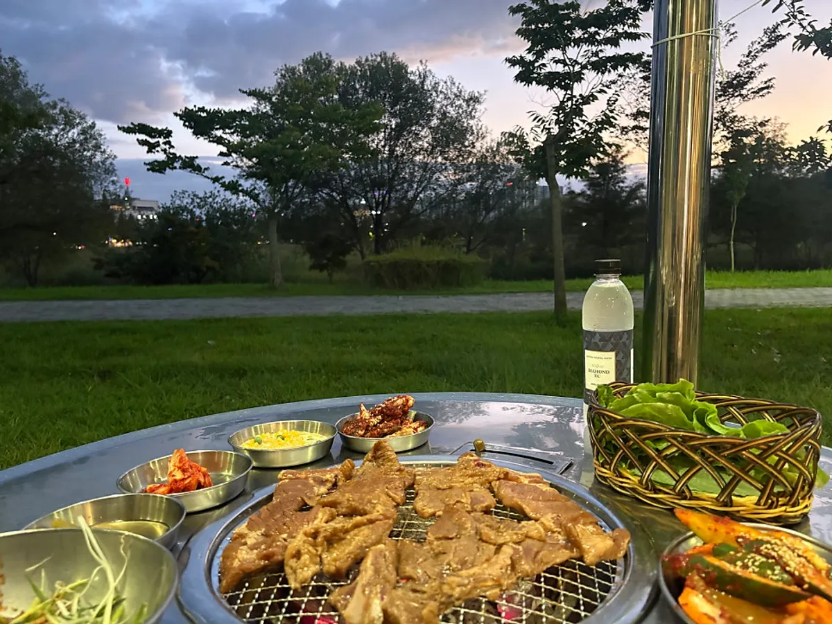 Pork ribs cooking on charcoal by the lakeside outdoor table