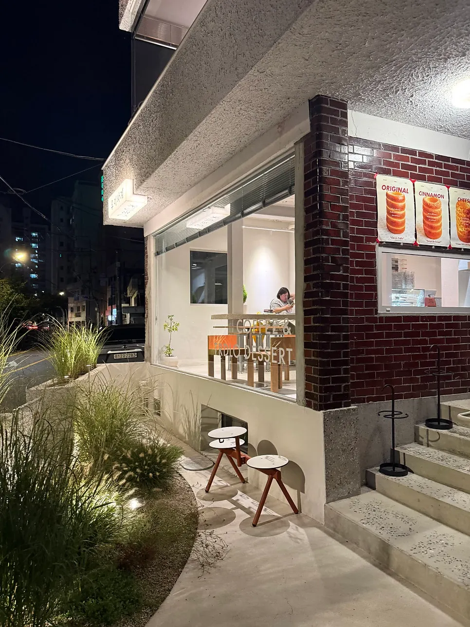 Café exterior wall with a bread-shaped sculpture and red beam accent