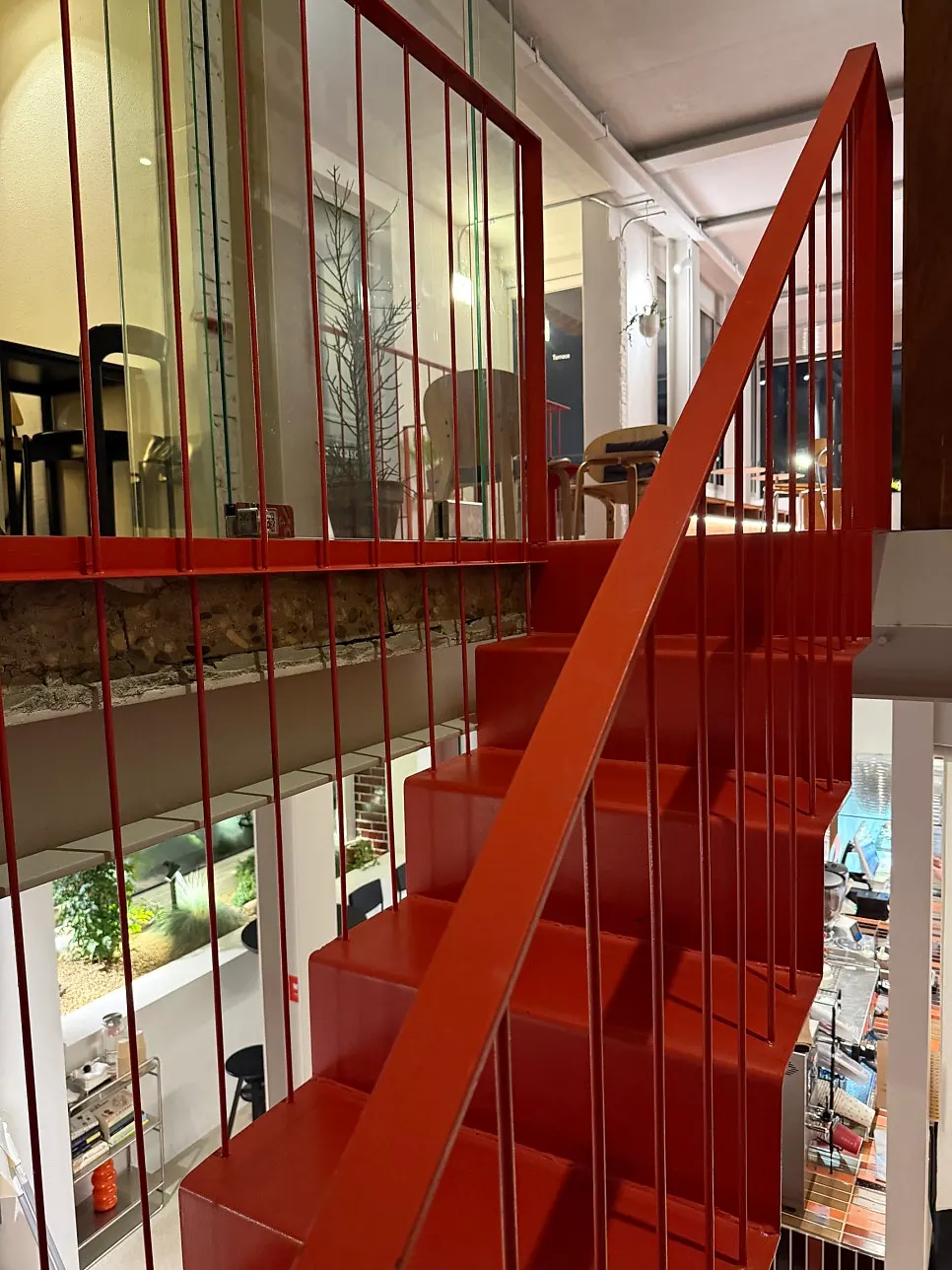 Bright red indoor stairs contrasting with white-toned interior