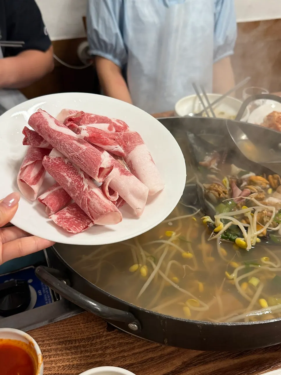 조개 아래 깔린 콩나물과 해물 국물