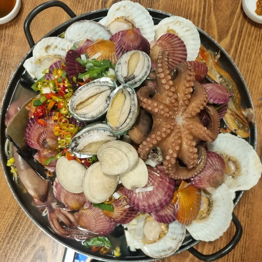 Seafood stew topped with live abalone and whole squid