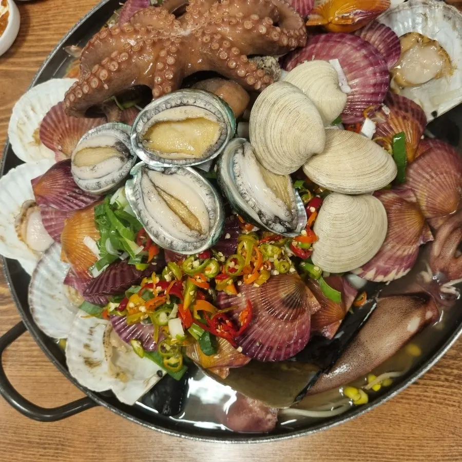 Inside the pot filled with scallops, crab, and raw clams