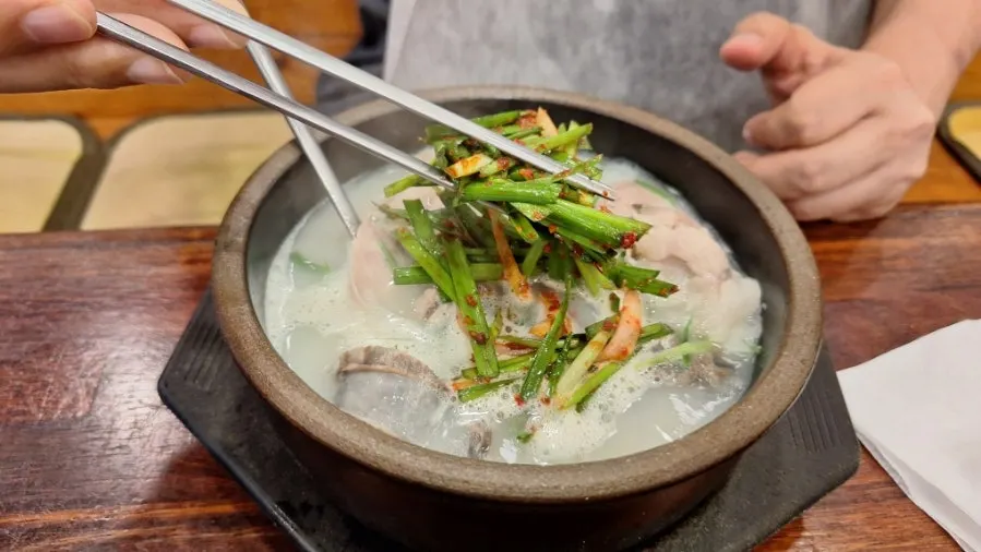Bowl of sundae gukbap with minced chives stirred in
