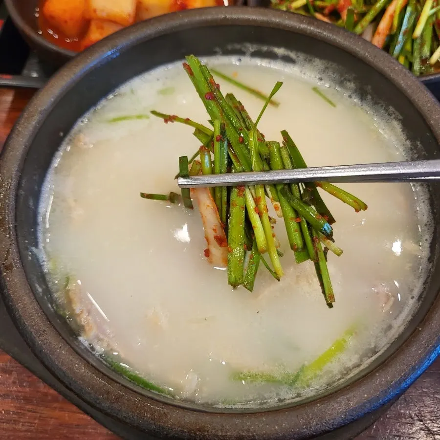 부추무침을 올린 살코기국밥 국물