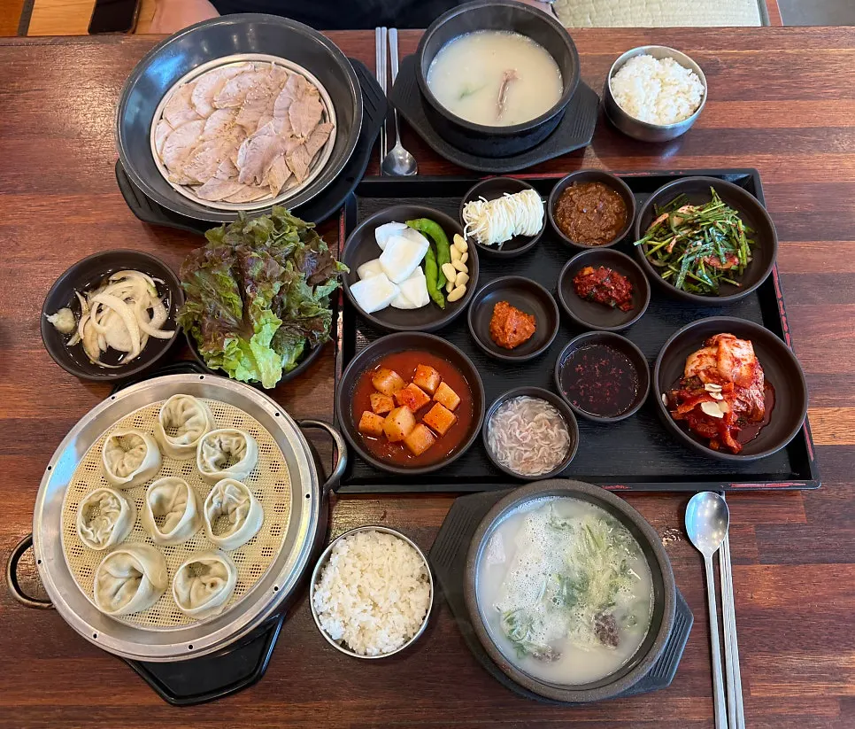Table spread of dishes ordered at Myeongin Dwaeji Gukbap