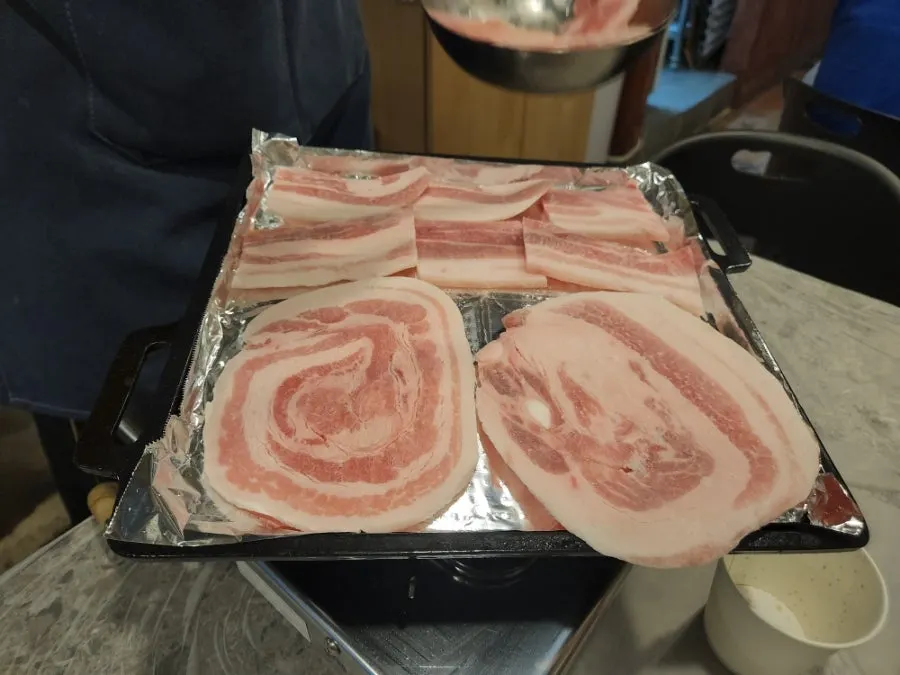 불판에 함께 굽는 김치와 마늘종