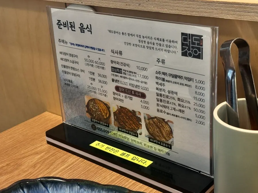 Menu board showing seasoned sea eel prices at Daedo Jangeo