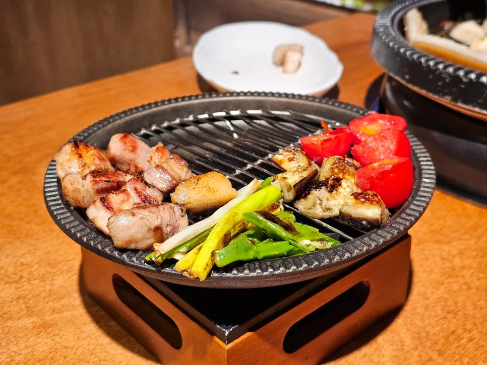 익은 고기와 가지·방울토마토가 올려진 불판