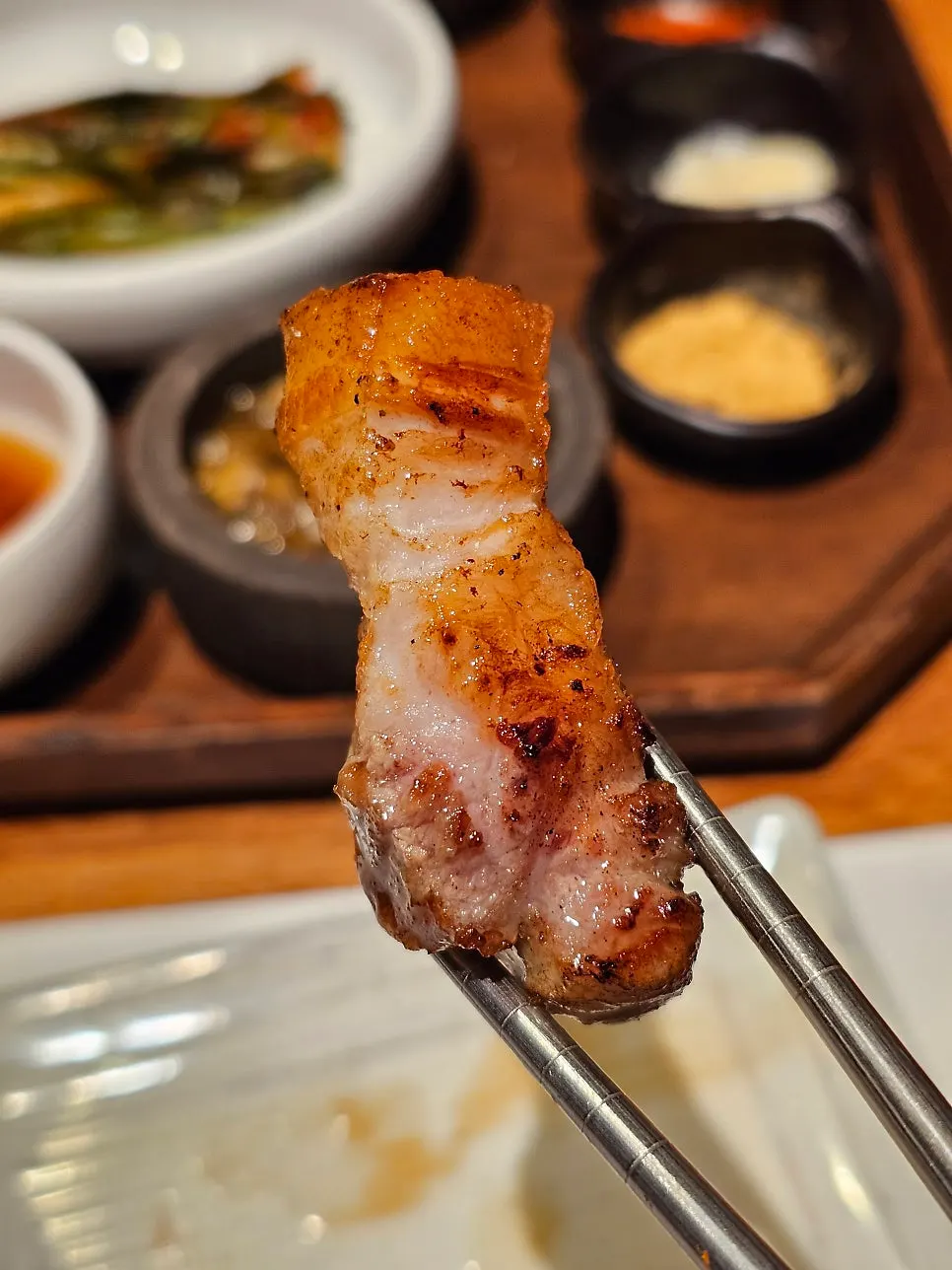 소금에 찍어 먹는 돼지고기 구이 한 점