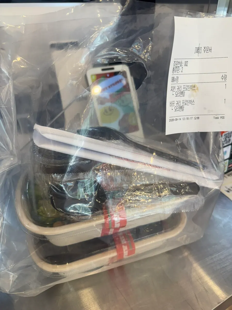 Two salads packed in takeout bags