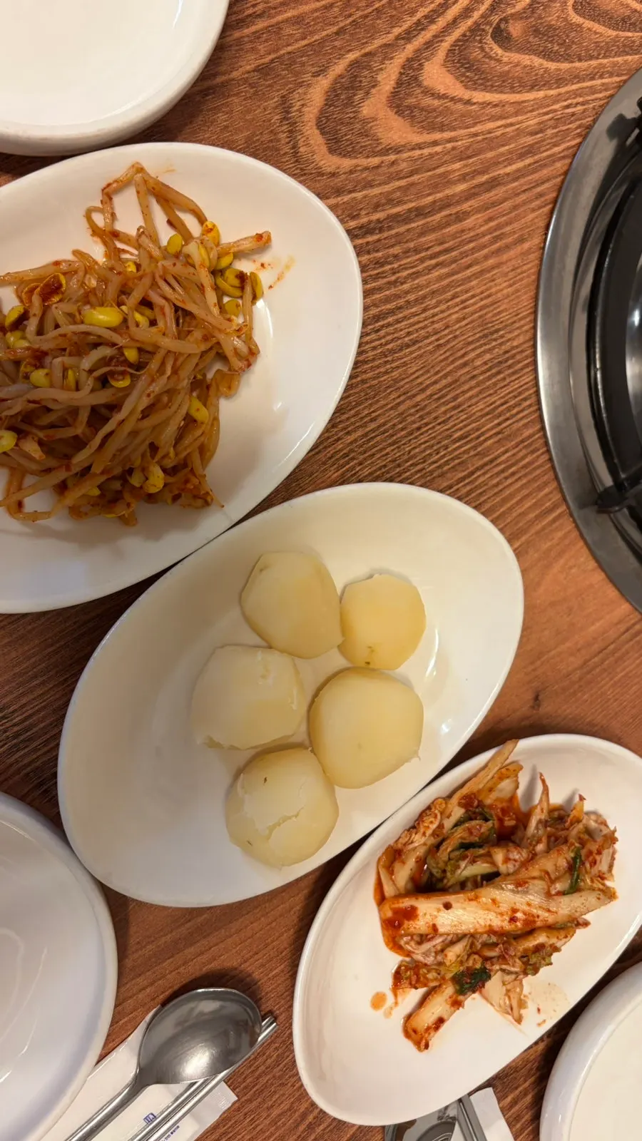 Basic side dishes of seasoned bean sprouts, boiled potatoes, and geotjeori