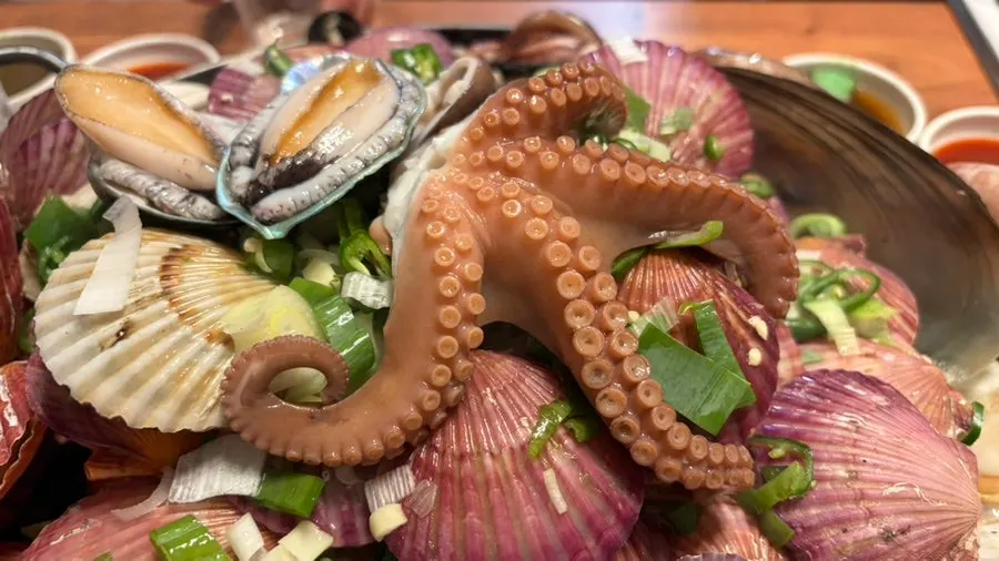 Octopus and shellfish cooking on the grill plate
