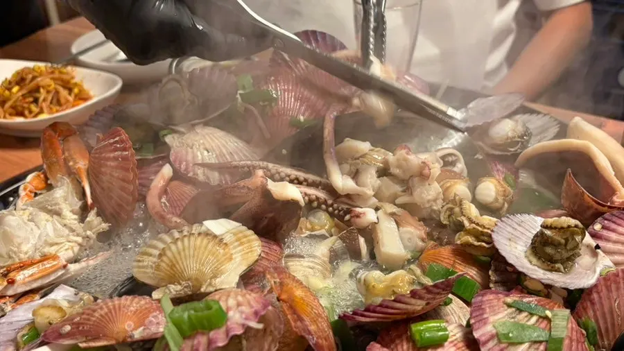 Staff member prepping seafood at the table