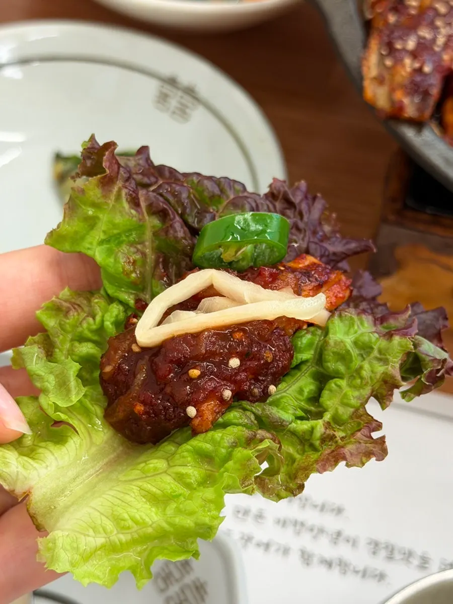 A piece of seasoned grilled eel being picked up