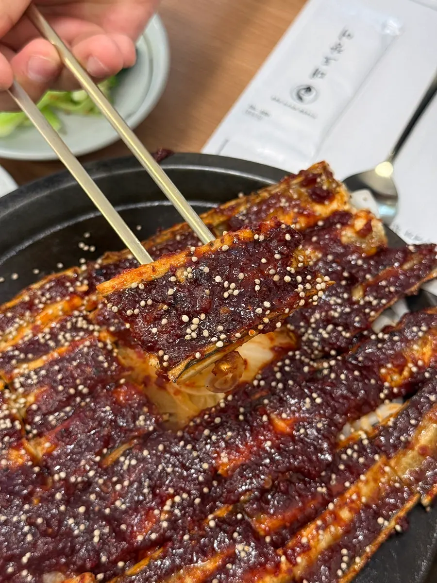 Eel generously coated in sauce with onions layered underneath