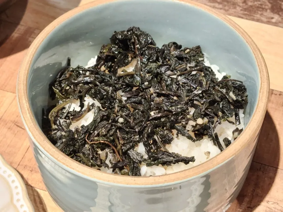 Two-person portion of gondeurae rice piled high with greens