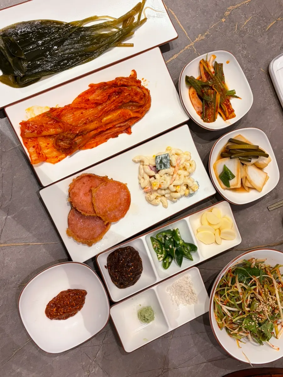Meat table spread with pickled wild garlic leaves and side dishes