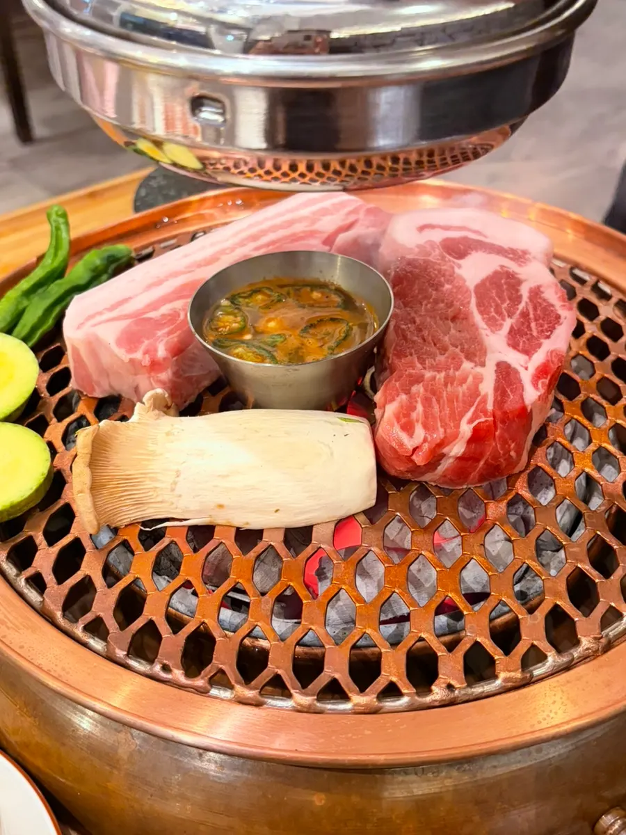 Staff grilling black pork over charcoal