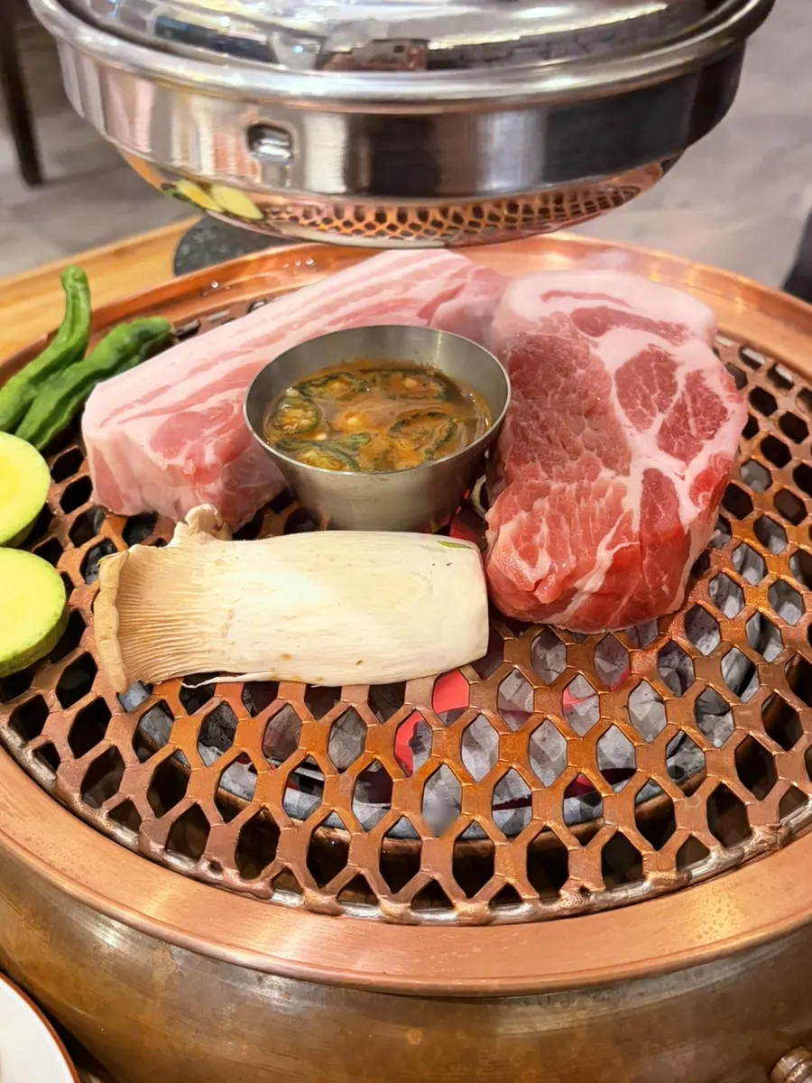 Staff grilling black pork over charcoal