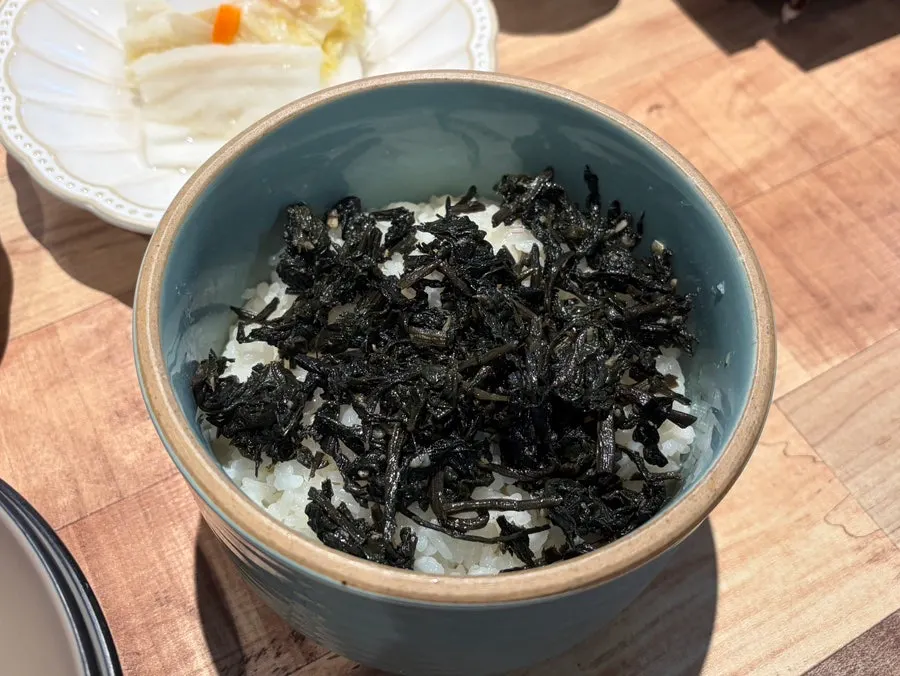 擺著蛤蜊嫩豆腐鍋與小菜的桌面