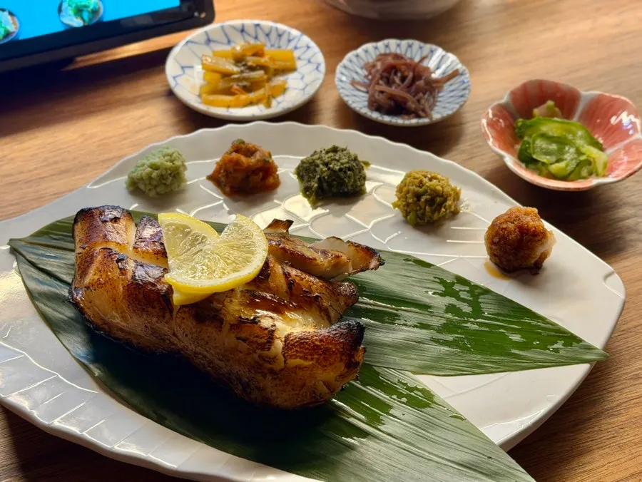 Charcoal-grilled merou with accompanying sauces on the table