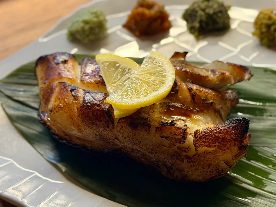 Close-up of the golden-brown charcoal-grilled merou