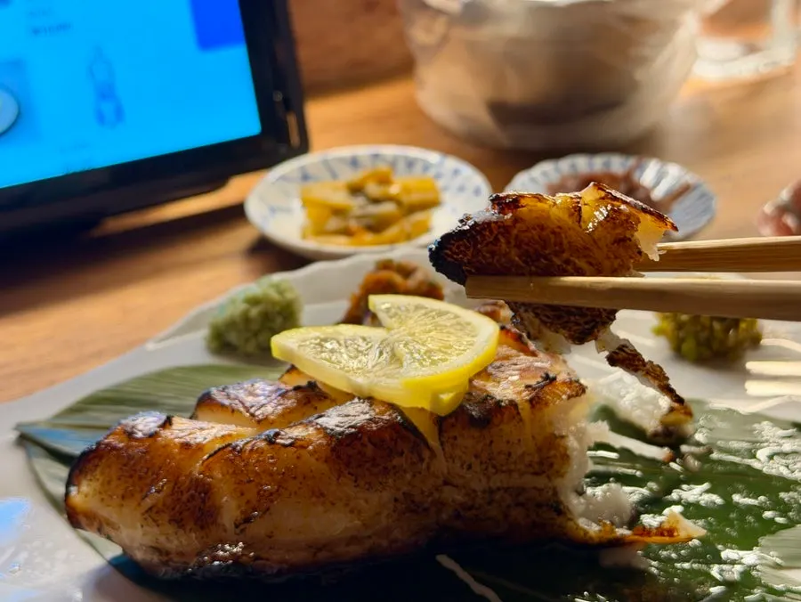 A piece of grilled merou torn open to show the flesh inside