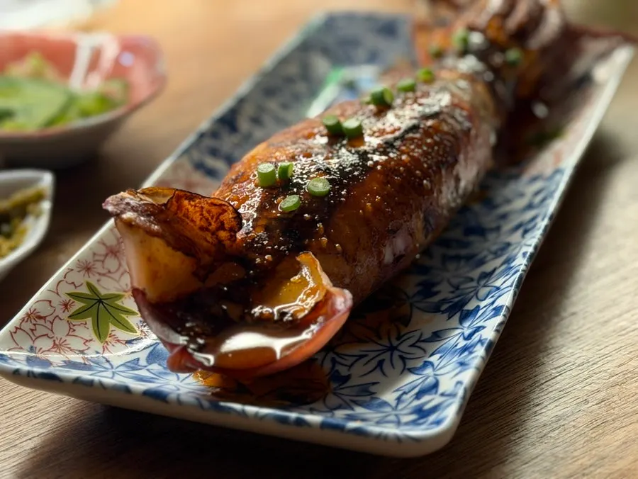 Cutting the charcoal-grilled whole squid with scissors