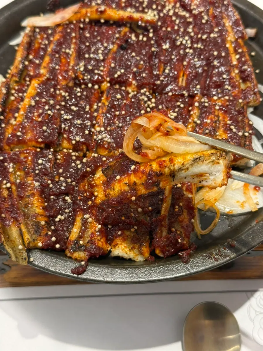 Charcoal-smoked sea eel over a bed of onions