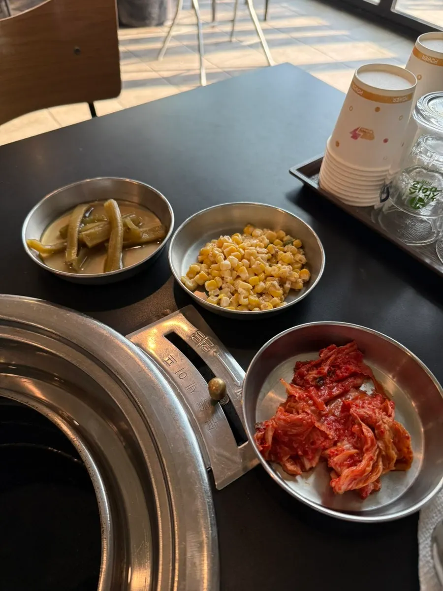 Side dishes with shredded scallions, gungchae pickles, and lettuce wraps