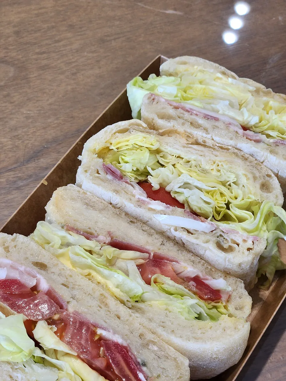 Cross-section of a ciabatta sandwich with bacon, lettuce, and tomato