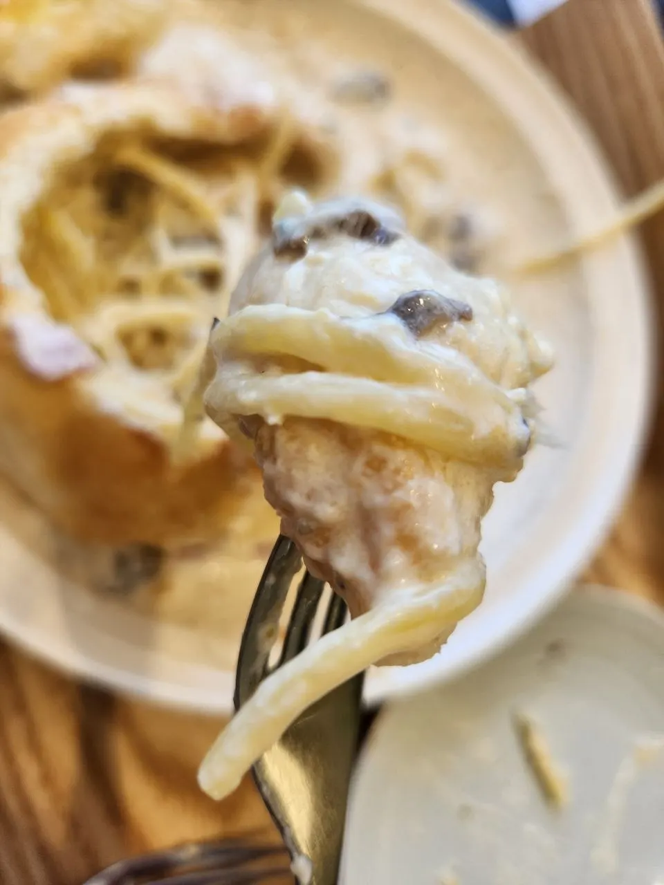 Tearing off a piece of panne bread and dipping it in cream sauce
