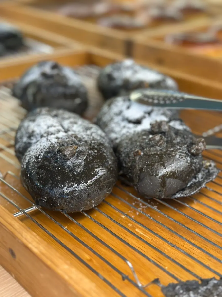 Chocolate baguette and squid ink cheese bread on display