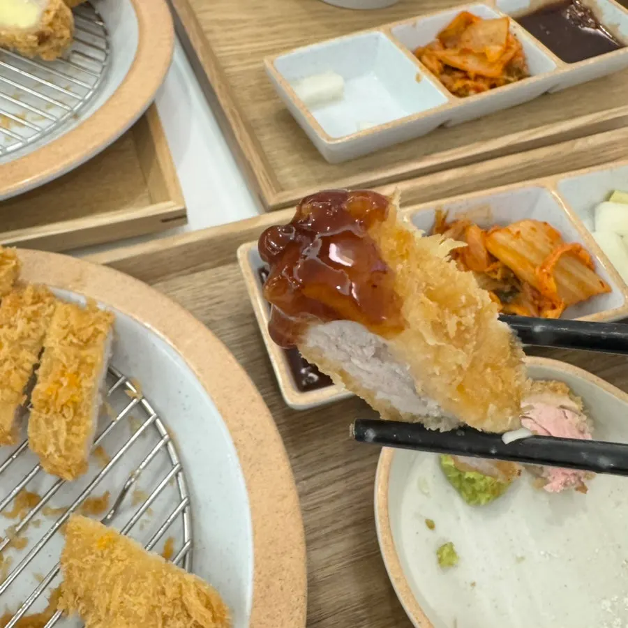 Sauce and side dishes served with Jeongseong Katsu's pork cutlets