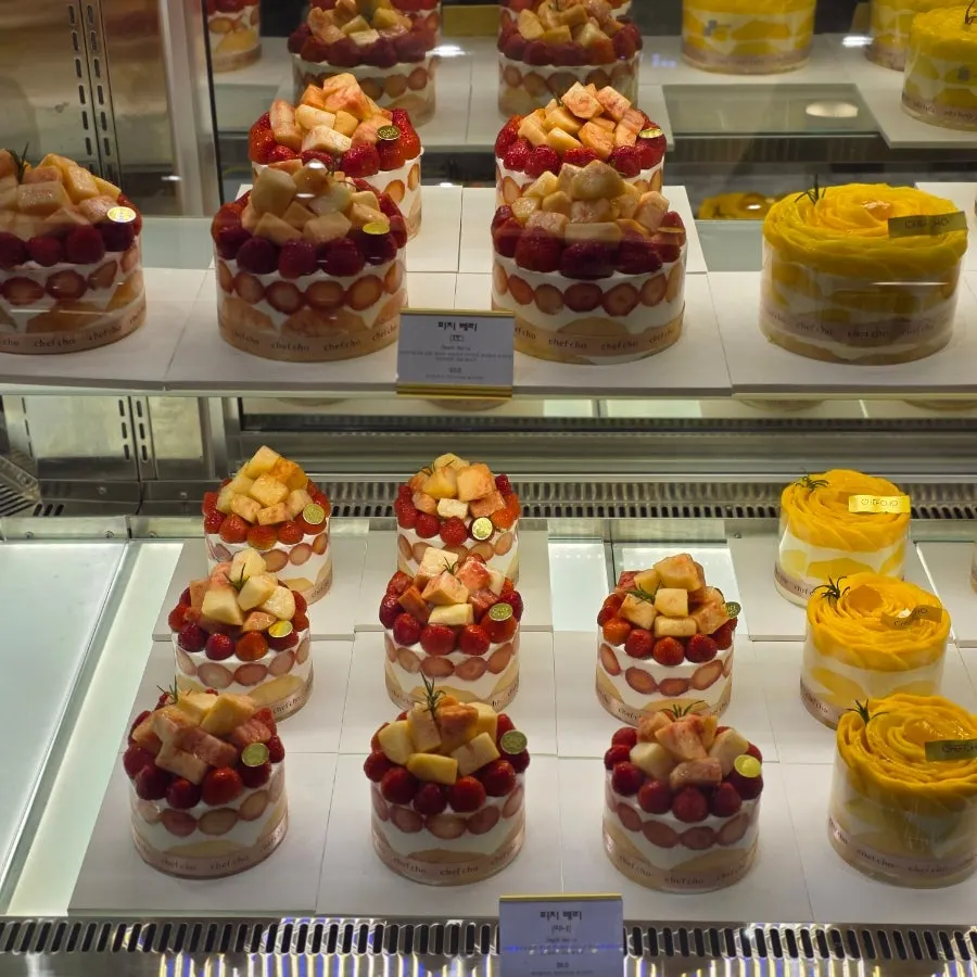 Whole cakes topped with seasonal fruit on display at Chef Cho