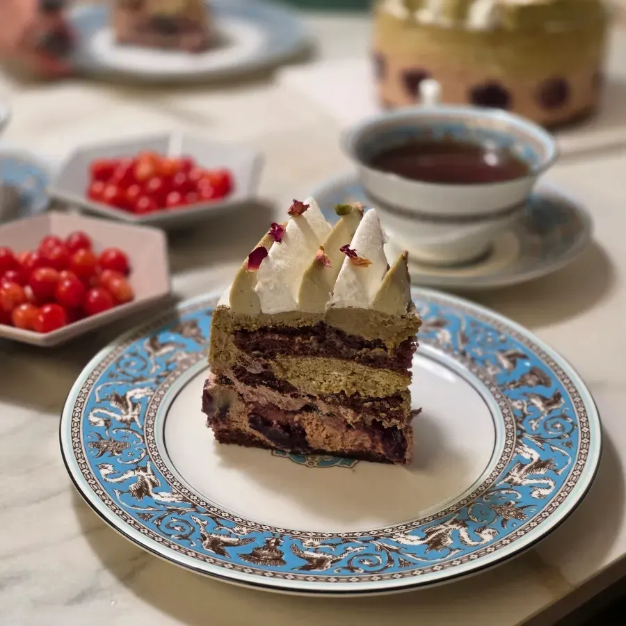 Slice of pistachio chocolate cake studded with cherries