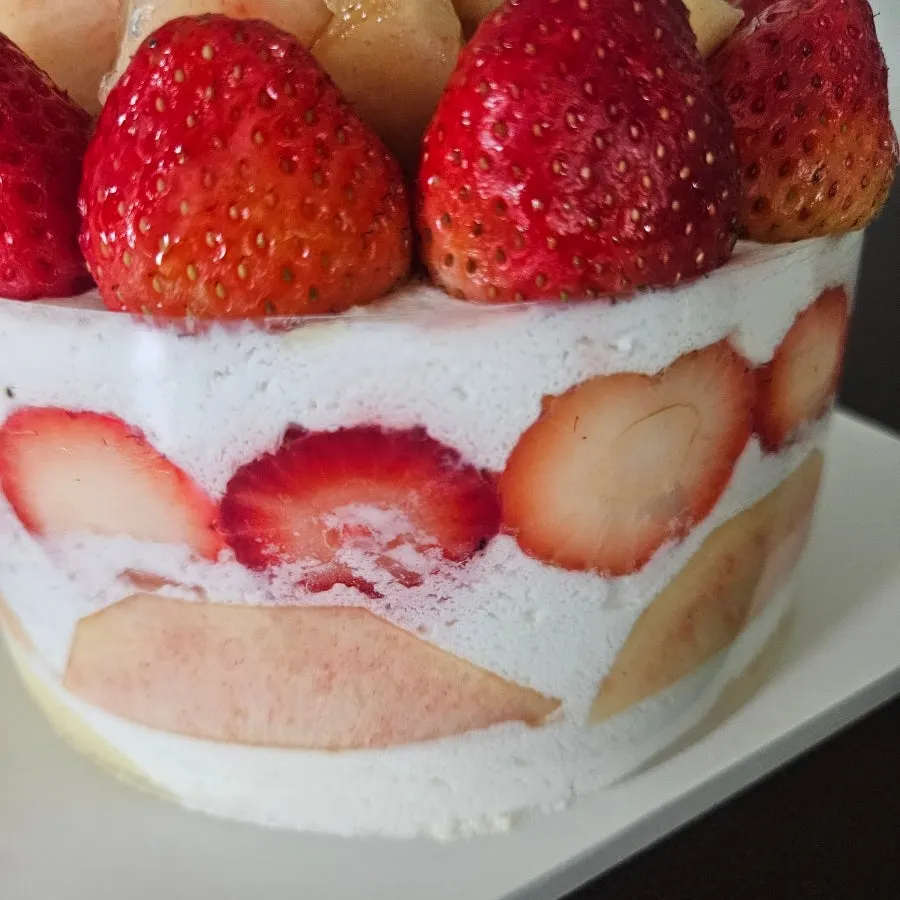 Peach Berry cake with the band removed and the fruit toppled