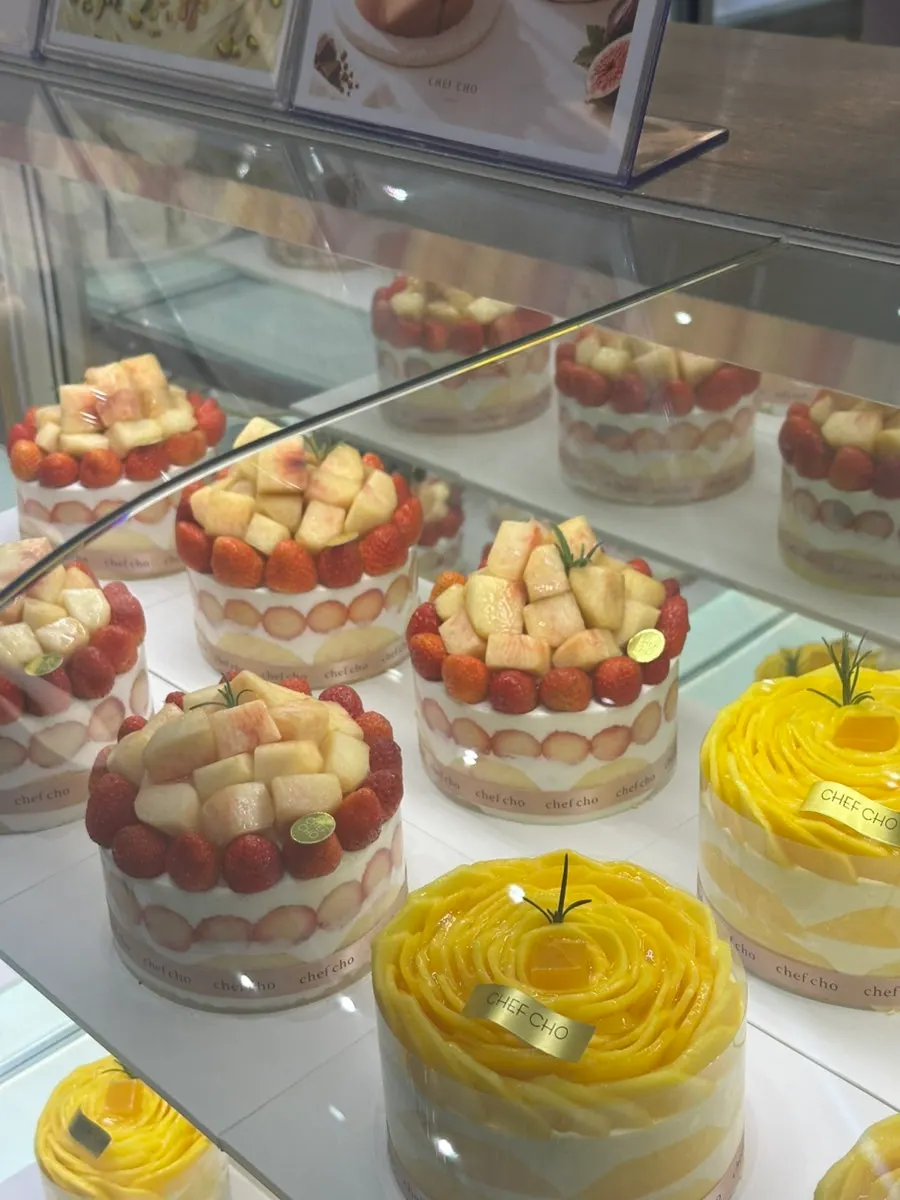 Peach strawberry cake and mango cake in the display case