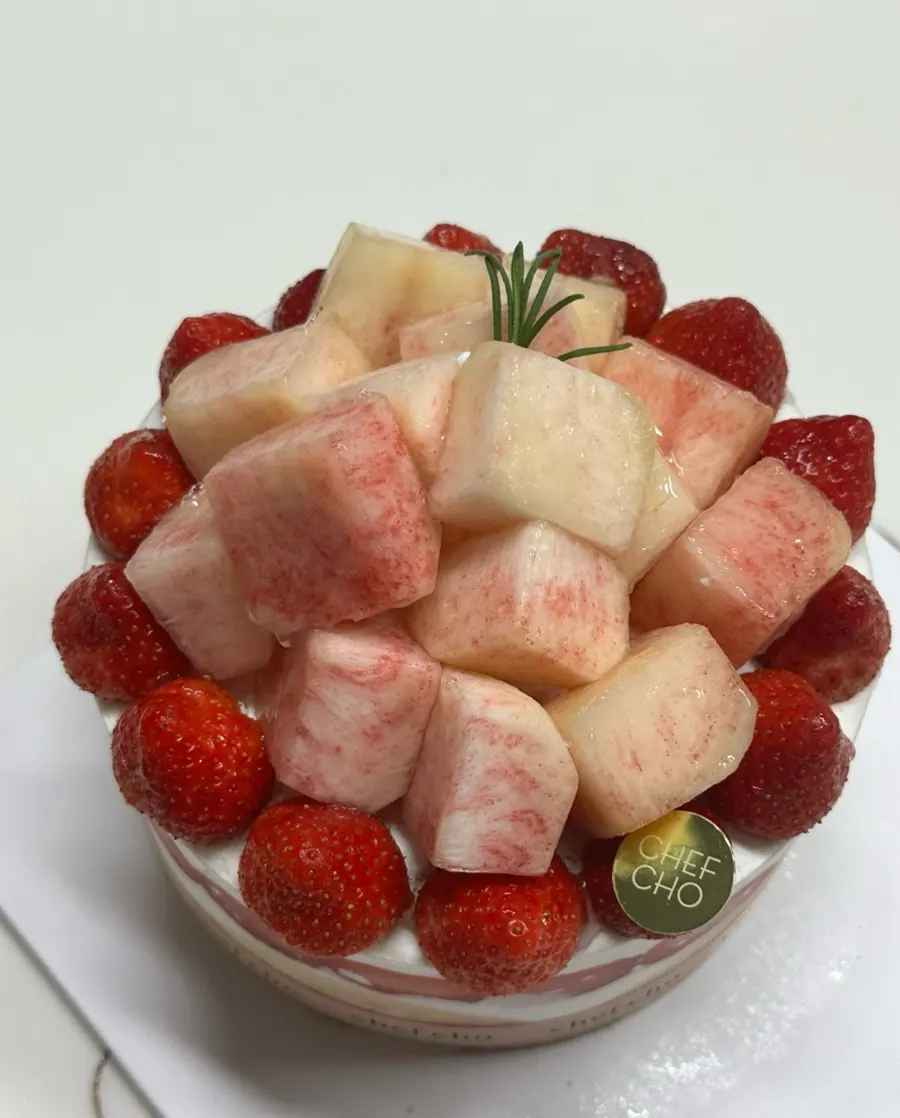 Permukaan atas kek Peach Berry penuh strawberi dan pic