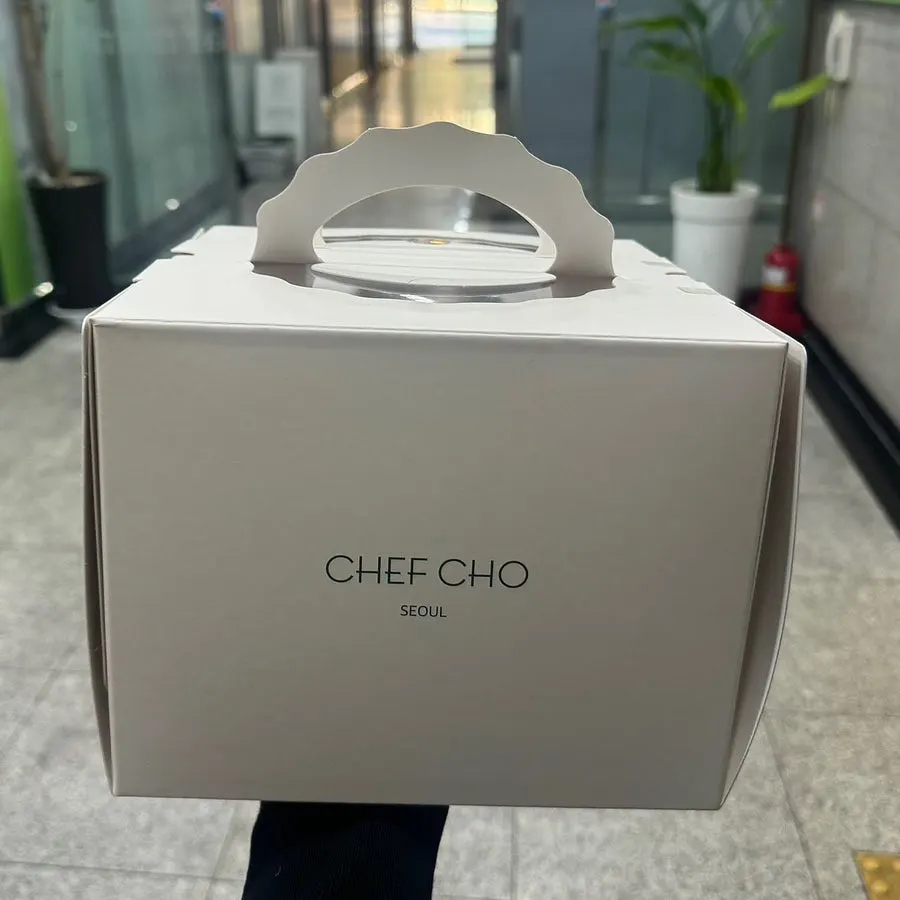 Shopping bag with a packaged Chef Cho cake