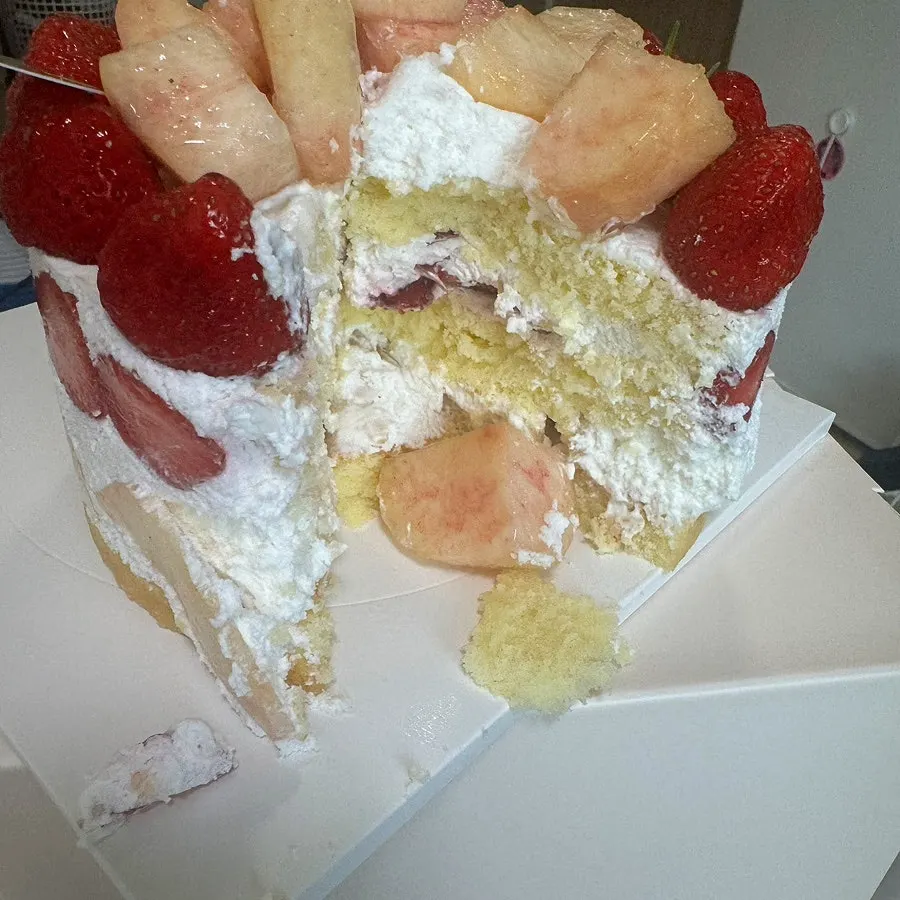 Cross-section of the cake showing whipped cream between the fruit
